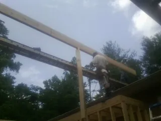 Carpenter setting a ridge beam over a new addition frame — Ice Dam Removal by Roofing Brothers in Farmdale