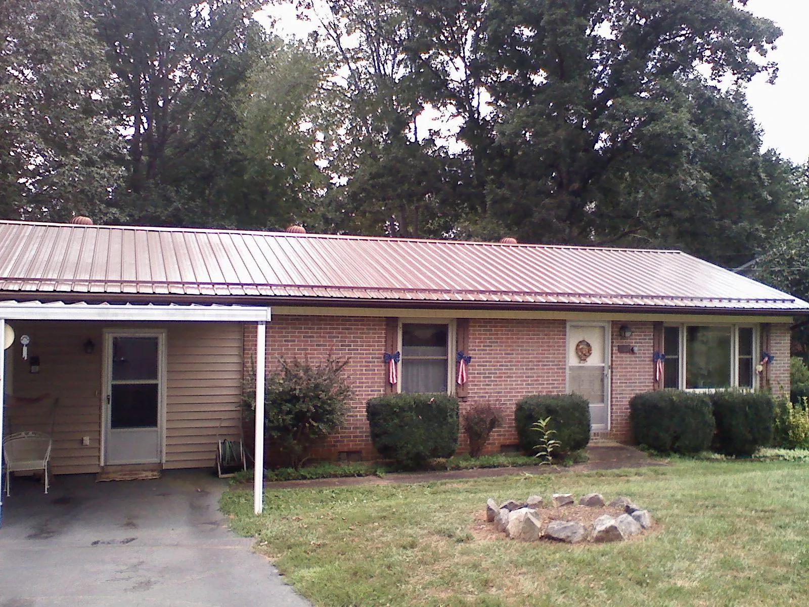 Bronze metal roof and carport on a brick ranch home — Roof Repair work by our crew in Farmdale